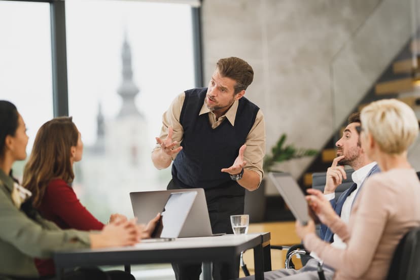 Four people talking around a table in a meeting room